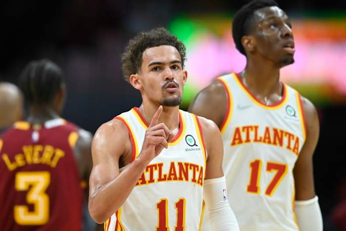Trae Young walks beside teammate Onyeka Okongwu.